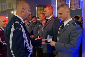 policjant wręcza kryształowe serce funkcjonariuszowi