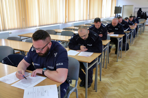 policjanci siedzą w ławkach i rozwiązują test