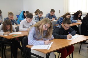 Fotografia przedstawia uczniów rozwiązujących test konkursowy.