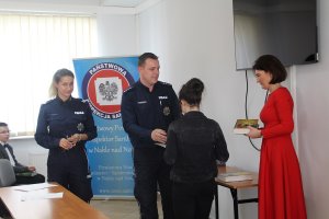 Fotografia przedstawia zaproszonych gości oraz policjantów rozdających nagrody uczestnikom konkursu.