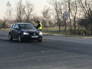 na zdjęciu policjantka przeprowadza kontrole drogową pojazdu