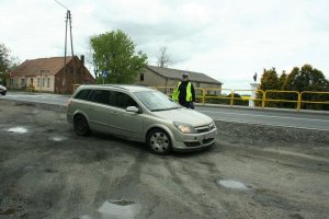 zdjecie przedstawia umundurowaną policjantkę ruchu drogowego kontrolującą auto