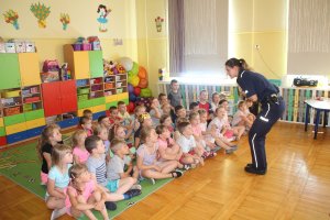 Zdjęcie przedstawia umundurowaną policjantkę prowadzącą zajęcia dla przedszkolaków.