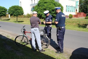 zdjęcie przedstawia umundurowanych policjantów ruchu drogowego prowadzących kontrolę rowerzysty