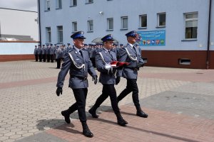 Zdjęcie przedstawia uroczystość Święta Policji - poczet flagowy idący z flagą państwową