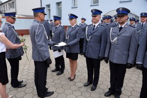 Zdjęcie przedstawia uroczystość Święta Policji - policjanci otrzymują awanse na wyższe stopnie służbowe