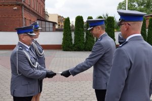 Zdjęcie przedstawia uroczystość Święta Policji - policjanci otrzymują awanse na wyższe stopnie służbowe