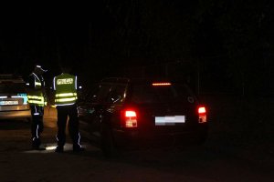 Zdjęcie przedstawia policjantów patrolowych kontrolujących pojazd osobowy