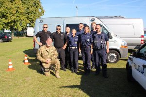 zdjęcie przedstawia umundurowanych policjantów, którzy wzięli udział w festynie. policjanci pozują do zdjęcia.