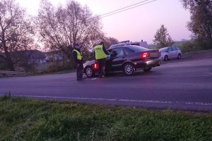 Zdjęcie przedstawia umundurowanych policjantów prowadzących kontrolę trzeźwości kierowcy auta osobowego