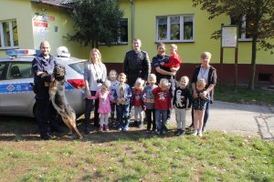 Zdjęcie przedstawia dzieci pozujące do fotografii wspólnie z policjantami i opiekunkami.