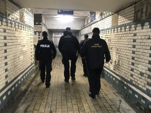 Zdjęcie przedstawia policjantów wspólnie z pracownikami Służby Ochrony Kolei kontrolujących tunel podziemny na dworcu kolejowym