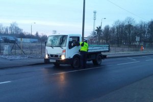 Zdjęcie przedstawia umundurowaną policjantkę sprawdzającą trzeźwość kierowcy auta dostawczego