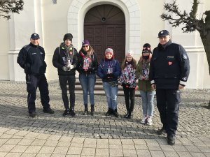 Zdjęcie przedstawia umundurowanych policjantów pozujących do fotografii wspólnie z wolontariuszami WOŚP