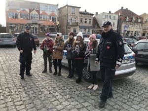 Zdjęcie przedstawia umundurowanych policjantów pozujących do fotografii wspólnie z wolontariuszami WOŚP