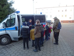 Zdjęcie przedstawia policjantkę prezentującą harcerzom oznakowany radiowóz