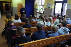 Policjantka omawia zasady bezpieczeństwa w czasie ferii uczniom SP Dobieszewo.