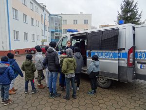 Policjantka pokazuje uczniom  radiowóz policyjny