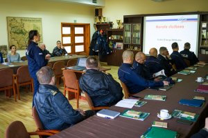 Zdjęcie przedstawia umundurowana policjantkę omawiającą zagadnienia dotyczące bezpieczeństwa w lasach