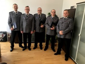 Zdjęcie przedstawia policjantów odchodzących na emeryturę wraz z przełożonymi