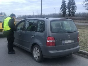 Zdjęcie przedstawia umundurowanych policjantów prowadzących kontrole drogową.