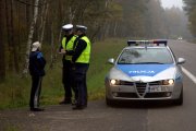 Zdjęcie przedstawia policjantów ruchu drogowego rozmawiających przy trasie z osobą.