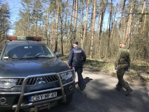 Zdjęcie przedstawia policjanta i strażnika leśnego wspólnie kontrolujących tereny leśne