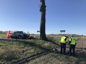 Zdjęcie przedstawia miejsce wypadku i pracujących na miejscu zdarzenia policjantów