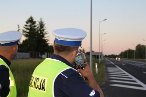 Zdjęcie przedstawia policjantów ruchu drogowego kontrolujących prędkość pojazdów