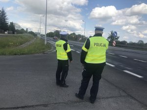 Zdjęcie przedstawia policjantów ruchu drogowego obserwujących ruch pojazdów