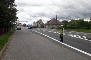 zdjęcie przedstawia policjanta ruchu drogowego zatrzymującego do kontroli pojazd typu bus