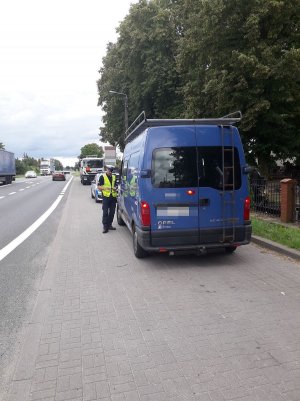 policjant przeprowadza kontrolę drogową pojazdu