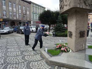 delegacja policjantów składa kwiaty pod pomnikiem na płycie rynku