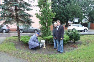 komendant zapala znicz pod pomnikiem pamięci