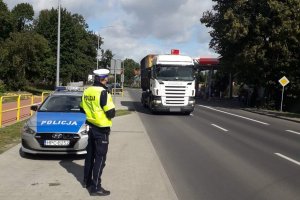 zdjęcie przedstawia policjanta ruchu drogowego obserwującego ruch pojazdów