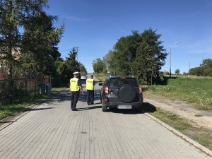 policjanci kontrolują auto koloru ciemnego