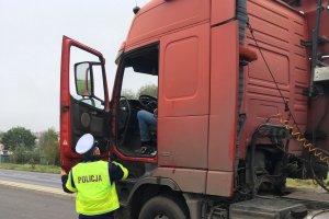 policjant kontroluje auto ciężarowe