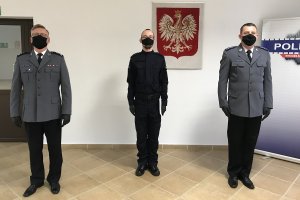 ślubowany policjant pozuje do zdjęcia wspólnie z przełożonymi