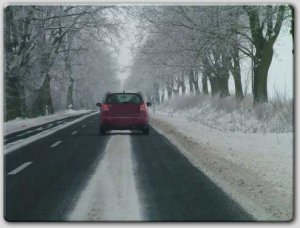 auto jadące trasą. po bokach widoczny śnieg