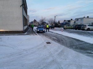 policjant stoi przy kontrolowanym aucie