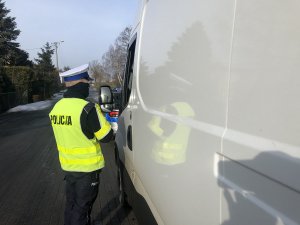 policjant kontroluje busa koloru białego