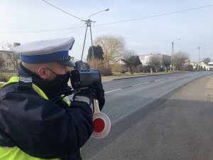 policjant sprawdza prędkość aut jadących trasą