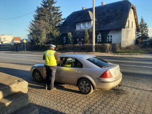 policjant kontroluje auto osobowe