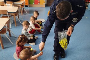 policjant rozdaje dzieciom odblaski