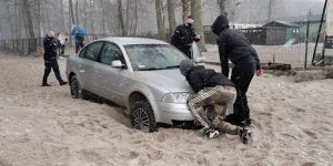 auto na plaży wypychane przez osoby