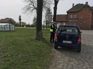 policjant kontroluje auto osobowe