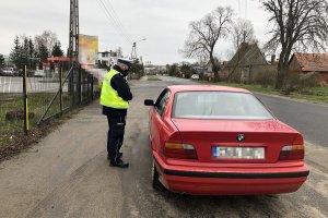 policjant kontroluje auto osobowe