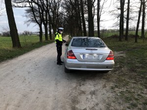 policjant kontroluje auto osobowe