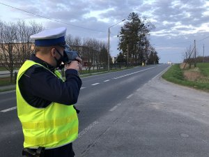 policjant kontroluje prędkość nadjeżdżającego auta urządzeniem