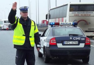 zdjęcie ilustracyjne. policjant zatrzymuje dłonią auto do kontroli